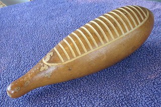 A wooden guiro is sitting on a blue cloth.