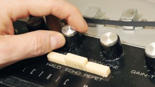 A hand is holding a knob on an old record player, creating a timewarp effect.