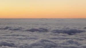 A view of the clouds from an airplane at sunset, creating a sparse and captivating soundscape.