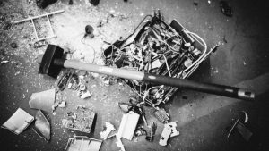 A black and white photo of a hammer on the ground, making a big impact.