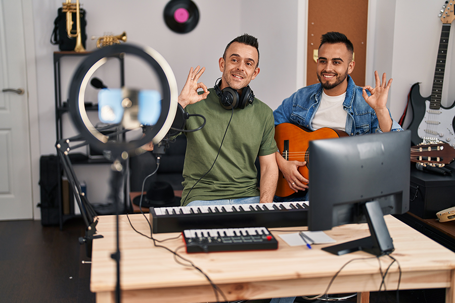 a couple of men sitting in front of a computer